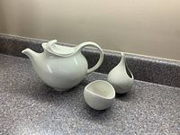 Teapot, sugar bowl and creamer on countertop