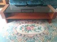 Full view of coffee table showing smoked glass top, teak frame and shelf
