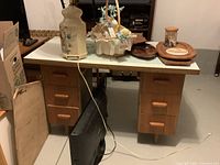 Front view of teak desk showing six drawers, tapered legs and overall structure
