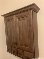 Front view closed showing two doors, four drawers, crown molding