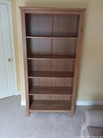 Front view of full-height wooden bookcase with five shelves