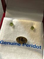 Pair of peridot stud earrings in box showing 14kt and Genuine Peridot label
