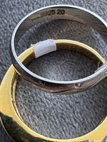 Inside view showing S925 20 hallmark on silver ring and gold plating on second ring