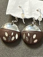 Front view of both earrings showing silver and wood halves with leaf motif