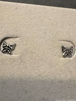 Full view of both butterfly earrings mounted in display pad