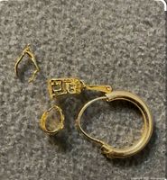 All four gold pieces laid out: 14K hoop, small ring, charm, ear-wire fragment