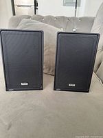 Front view of both black TEAC speakers with grilles visible