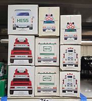 Stack of nine Hess toy boxes showing fronts/backs including two 2015 Fire Truck boxes and others