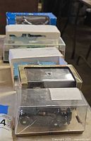 Stacked view of six acrylic-cased diecast vehicles