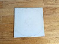 Front cover of white album gatefold showing embossing and ring wear