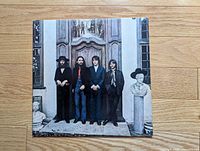 Front sleeve showing The Beatles standing by ornate wooden doorway