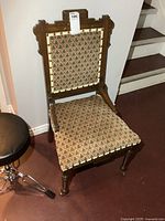 Front view of Eastlake style chair showing upholstery and carving