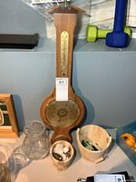 Front view of wooden barometer, vase, and buckets