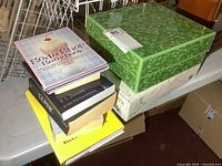 Stack of six novels next to two boxed kitchen items