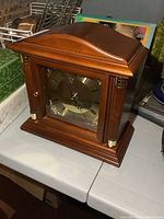 Front view of Bulova wooden mantel clock showing dial, glass door, columns