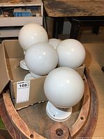 Box containing five white glass globes and four bases
