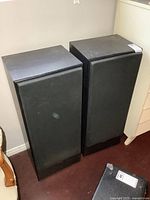 Pair of black JVC tower speakers side by side