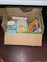 Top view of cardboard box filled with children’s books