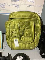 Front view showing quilted exterior, two front zip pockets and carry handles