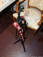 Full view of microphone stand with guitar strap draped over chair