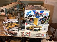 Stack of six model kit boxes on workbench