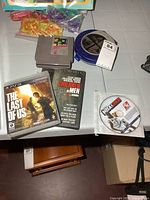 Group shot showing all items: PS3 game, NES cartridge, DVD, CD case, NBA disc