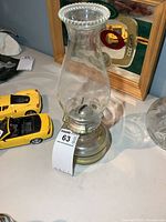 Full view of glass oil lamp with surrounding objects for scale