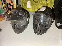 Both paintball masks side by side on table