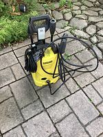 Front view of Kärcher electric pressure washer showing housing, hose and cord