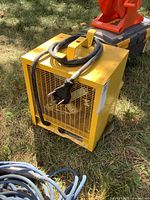 Front angled view of yellow Westcan shop heater showing power cord and plug