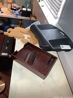 All items on table: wooden paper tray with holders, black laptop pad, light wood board