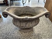 Top view of resin urn planter showing fluted bowl, scroll handles, weathered patina