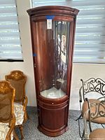 Full view of closed curved glass cherry curio cabinet