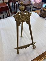 Front view of ornate brass easel standing
