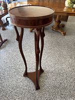 Full view of pedestal side table showing overall shape and finish