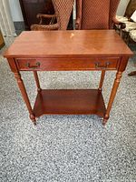 Front view of console table showing drawer, legs and shelf