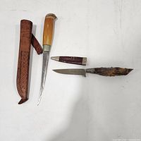 Both knives and their sheaths laid out