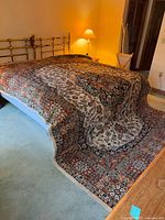 Rug draped over bed showing full pattern and size