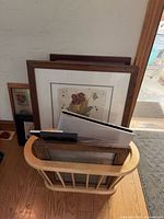 Magazine rack with assorted framed prints and frames