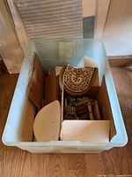 Plastic bin holding miniature furniture pieces