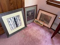Four framed pieces leaning against wall