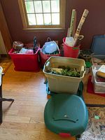 Group of red, beige and green storage totes with gift-wrap rolls, ribbons and garland