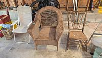 three chairs: folding metal, wicker armchair, wooden side chair