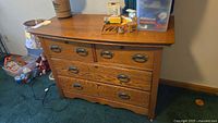 Front view showing all five drawers, brass pulls, tiger-oak grain