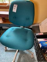 Front view of teal Steelcase armless task chair showing seat, back and base