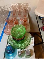 Table view showing mixed pressed glass items in various colours and types