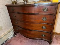 Front view showing serpentine profile and four drawers