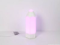 Full view of pencil-shaped LED lamp emitting pink light