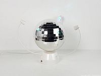 Lamp off showing mirror ball, base, two LED arms