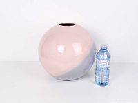 Front view of spherical vase beside water bottle for scale